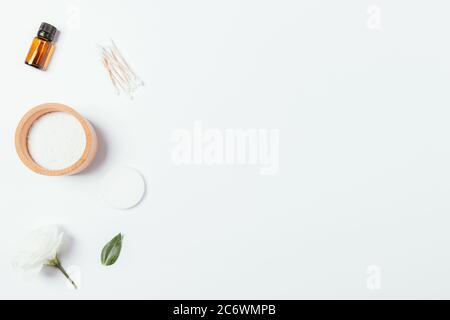 Badesalz in Holzschale, ätherisches Öl, Wattepads und Tupfer auf weißem Hintergrund mit Kopierraum. Stockfoto