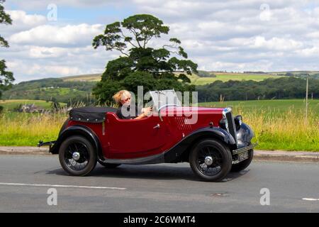 1936 Vorkriegszeit 30s Red Morris 8 Cabrio-Verdeck; Fahrzeuge mit fahrendem Verkehr, 1930s Autos, die Fahrzeuge auf britischen Straßen fahren, Motoren, auf dem Autobahnnetz der Autobahn M6 fahren. Stockfoto