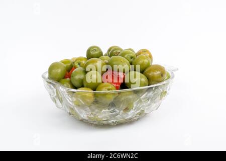 Marinierte Oliven in kleiner transparenter Schüssel. Auf weißem Hintergrund. Eingelegte grüne Oliven Stockfoto