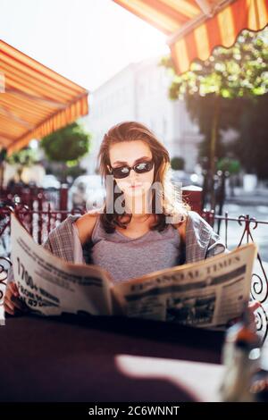 Minsk, Weißrussland - 19. Juni 2020: Beschäftigte beschäftige energische Frau am Cafeteria-Tisch, die die neuesten Nachrichten in einer Zeitung liest - klassischer Stil Stockfoto