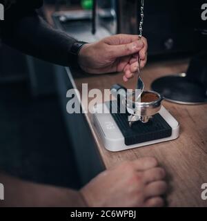 Nahaufnahme eines professionellen Barista, der unter Druck aromatischen starken Kaffee braut - frischer Cappuccino und Espresso am Morgen Stockfoto
