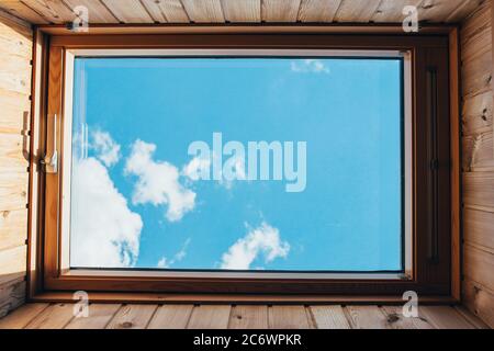 Klares blaues Himmelsrechteckige Innenansicht durch das Dachfenster Stockfoto