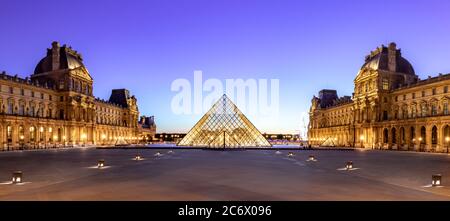 Louvre Museum bei Nacht Weitwinkel, ist das weltweit größte Kunstmuseum und ein historisches Denkmal in Paris, Frankreich. Ein zentrales Wahrzeichen der Stadt Stockfoto