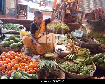 Eine ältere Frau verkauft Gemüse in einem Geschäft in einem Markt in Kalkutta, Indien, 29. Oktober 2007. Stockfoto