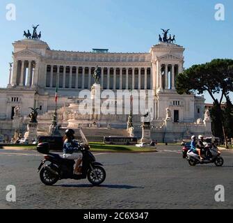 Motorräder passieren die Altare della Patria, "Altar des Vaterlandes", das Nationaldenkmal für König Viktor Emanuel II in Rom, Italien Stockfoto