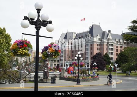 Blick auf hängende Blumenkörbe und das historische Fairmont Empress Hotel in der Innenstadt von Victoria, Britsih Columbia, Kanada auf Vancouver Island. Stockfoto