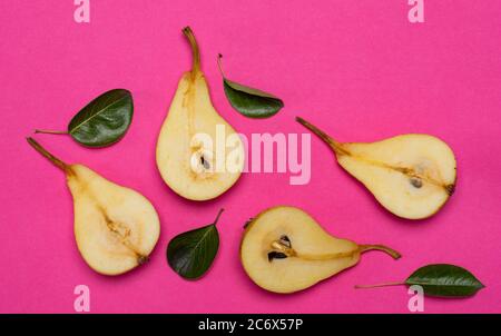 Frische Birnen mit Blättern auf rosa Hintergrund Draufsicht Stockfoto