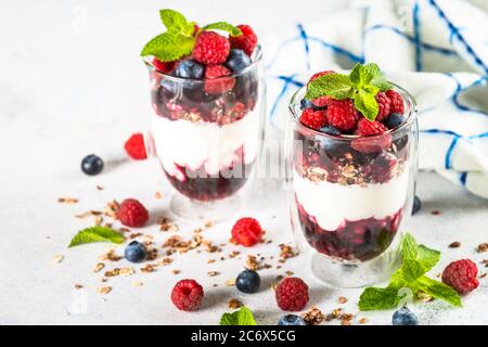 Parfait mit Müsli, Marmelade und frischen Beeren im Glas. Stockfoto