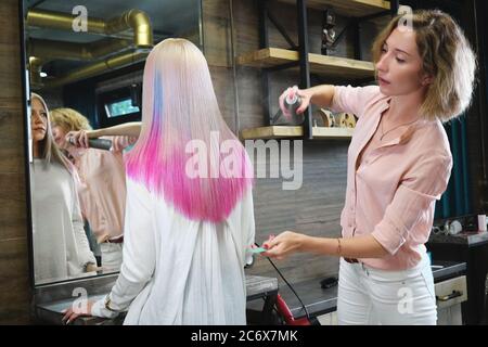 Schöne blonde Mädchen mit farbigen rosa Haar in einem Friseursalon. Stockfoto