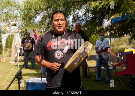 Oklahoma City, OK, USA. Juli 2020. Ein indigener Performer spielt eine Trommel über das Sit-in der Gesellschaft zum Schutz der indigenen Rechte und indigenen Verträge für den indigenen Widerstand, wo Demonstranten am 11. Juli 2020 friedlich gegen das Denkmal protestierten. Kredit: Leslie Spurlock/ZUMA Wire/Alamy Live Nachrichten Stockfoto