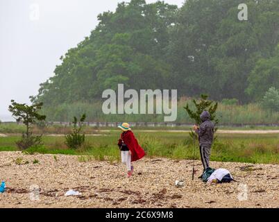 Ein Paar auf einem felsigen Shelter Island Strand Angeln in Der Regen Stockfoto