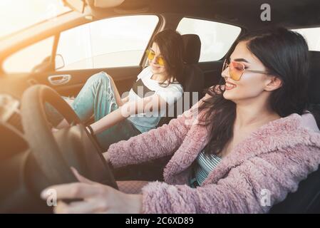 Zwei glückliche junge Frauen, die Spaß in einem Auto haben