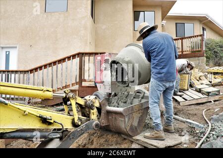 Mexikanische Arbeiter bauen eine Zementmauer mit Blick auf Morro Bay Mündung in Zentral-Kalifornien Stockfoto