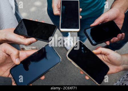 Gruppe von Freunden zusammen in einem Kreis mit dem Telefon auf einmal Stockfoto