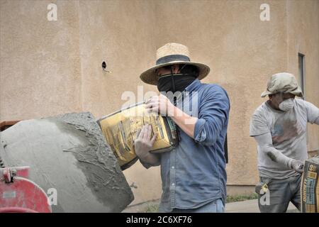 Mexikanische Arbeitskräfte bauen eine Zement Stützmauer mit Blick auf Morro Bay Mündung in Zentral-Kalifornien setzen Zement in Mischer für Fugen Stockfoto