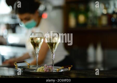 Weibliche Barkeeper tragen Gesichtsmaske bereiten Sekt Stockfoto