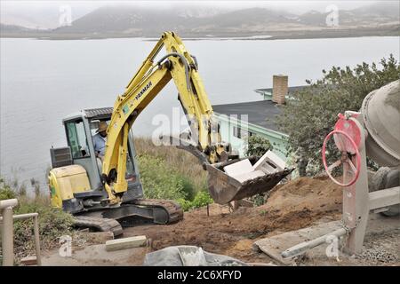 Mexikanische Arbeiter bauen eine Zementmauer mit Blick auf Morro Bay Mündung in Zentral-Kalifornien Stockfoto