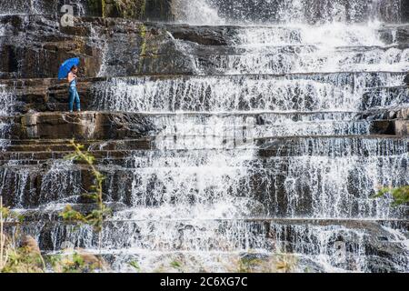 Frau beim Erkunden des Pongour Wasserfalls in der Nähe von Da Lat in Vietnam Stockfoto