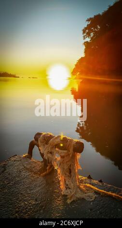 Sonnenaufgang Sonnenuntergang am Fluss 'Canal do estuário', zwischen den Städten Guaruja und Bertioga in Brasilien. Farbenfrohe und ruhige Sonnenaufgänge an einem ruhigen Fluss. Sli Stockfoto