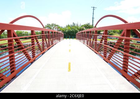 Rote Brücke außerhalb des Biscayne National Park in Homestead, Florida, Brücke, die zu Angelplätzen führt, Brücke über einen Kanal. Stockfoto