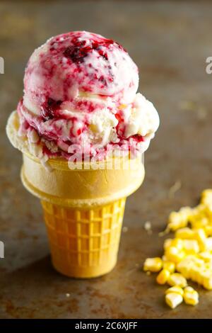 Süßes Maiseis mit Brombeersauce Stockfoto