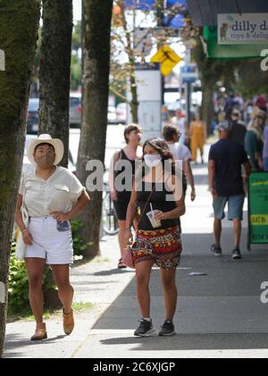 Vancouver, Kanada. Juli 2020. Menschen mit Gesichtsmasken gehen am 12. Juli 2020 auf einer Straße in Vancouver, British Columbia, Kanada. In der vergangenen Woche ist die Zahl der Neuerkrankungen in British Columbia stetig gestiegen. Am 10. Juli verkündeten die Gesundheitsbehörden der Provinz 25 neue Fälle, die größte Zunahme seit Anfang Mai. Ein UBC-Experte sagt, es gibt eine Möglichkeit, dass B.C. zu Sperrbedingungen zurückkehren könnte, wenn COVID-19 Fallzahlen weiter steigen. Quelle: Liang Sen/Xinhua/Alamy Live News Stockfoto