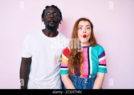 Interracial paar tragen lässige Kleidung, die Fische Gesicht mit Lippen, verrückt und komische Geste. Lustiger Ausdruck. Stockfoto