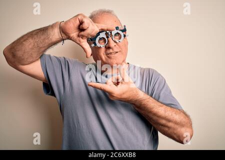 Mittelalter hory Mann Kontrolle Vision trägt Optometrie Brille über weißem Hintergrund lächelnd machen Rahmen mit Händen und Fingern mit glücklichen Gesicht. C Stockfoto