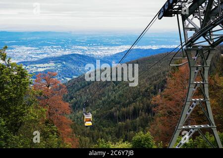 Freiburg, Deutschland. Juni 2020. Eine Unterstützung der Schauinsland-Seilbahn befindet sich in der Nähe der Bergstation auf dem Schauinsland, während eine Gondel bergab fährt. Die Schauinslandbahn ist die längste Seilbahn Deutschlands und war 1930 die erste ihrer Art weltweit. (To dpa: 'Deutschlands längste Umlaufbahn ist nicht Teil des alten Eisens Credit: Philipp von Ditfurth/dpa/Alamy Live News Stockfoto