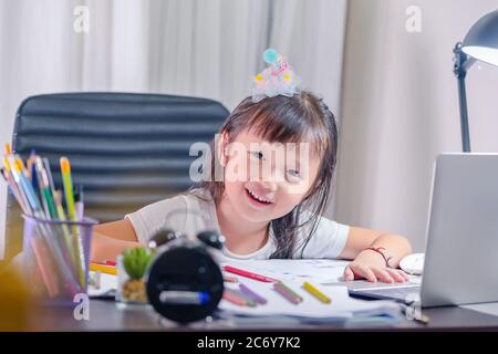 Asiatische kleine Mädchen im Kindergarten Schule Hausaufgaben Zeichnung und Malerei zu Hause Lächeln Gesicht und Blick auf Kamera Stockfoto