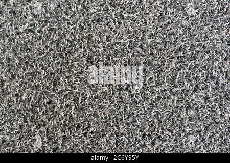 Die Bodenmatte besteht aus Kunststoff-PVC gemischt mit synthetischem Gummi. Weiche, schwammartige Textur mit dunkelgrauer Farbe. Stockfoto