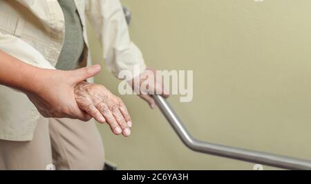 Ältere Frau, die mit der Pflegekraft am Handlauf festhält Stockfoto