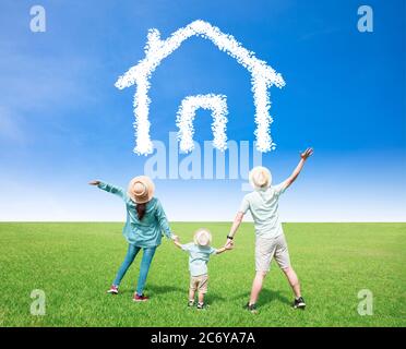 Glückliche Familie beobachten den Himmel mit Haus-und Haus-Symbol-Konzept Stockfoto