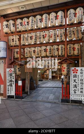 KYOTO, JAPAN - 22. OKTOBER 2007: Dekoriert von traditionellen japanischen Laternen, der Eingang zum Nishiki-Tenmangu Schrein auf der belebten Einkaufsstraße o Stockfoto