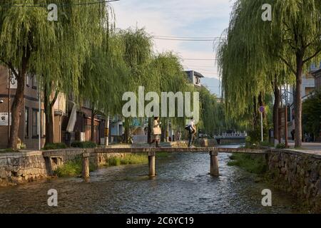 KYOTO, JAPAN - 23. OKTOBER 2007: Blick auf die schmale Steinbrücke Ippon (Ipponbashi) über den Shirakawa Kanal, gesäumt von Weidenbäumen. Kyoto, Japan Stockfoto