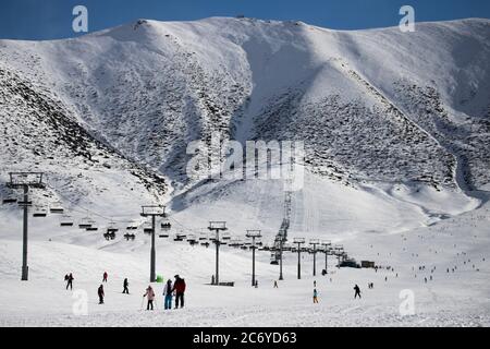 Touristen und Sportler erkunden die Pisten des Skistützpunktes Chunkurchak im Gebiet Chuy in Kirgisistan bei Bischkek. Stockfoto