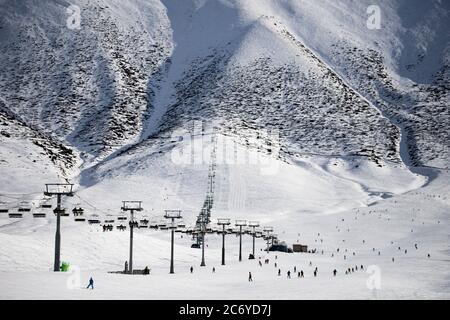 Touristen und Sportler erkunden die Pisten des Skistützpunktes Chunkurchak im Gebiet Chuy in Kirgisistan bei Bischkek. Stockfoto