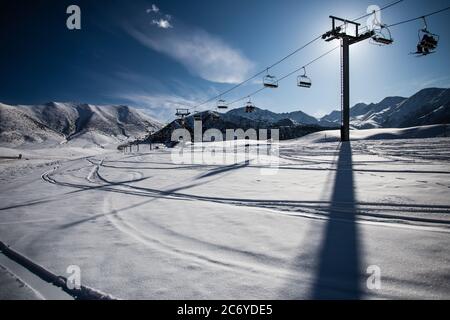 Touristen und Sportler erkunden die Pisten des Skistützpunktes Chunkurchak im Gebiet Chuy in Kirgisistan bei Bischkek. Stockfoto