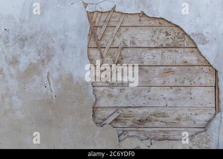 Die alte Mauer, die zerfällt. Man kann die Holzbretter sehen, aus denen das Haus gebaut wird. Strukturiert. Stockfoto