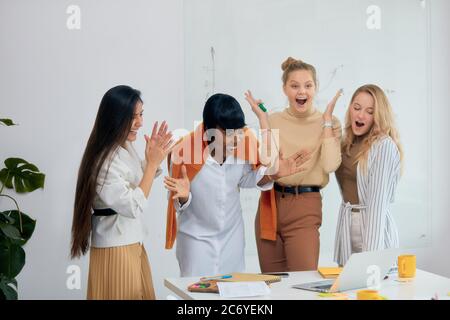 Überraschte Frauen in Freizeitkleidung im Büro zusammen, in Schock mit geöffnetem Mund. Feiern Sie ihren Sieg in Business-Projekt, gute Arbeit der vielfältigen weiblichen Stockfoto