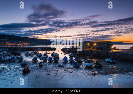 Lyme Regis, Dorset, Großbritannien. Juli 2020. Wetter in Großbritannien. Wolken driften über den Himmel über dem Cobb Hafen bei Lyme Regis in Dorset kurz vor Sonnenaufgang. Bildquelle: Graham Hunt/Alamy Live News Stockfoto