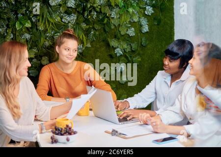 Junge multiethnische Team von kaukasischen und afrikanischen Frauen Coworking zusammen im Büro, entwickeln Business-Projekt, kreative Gruppe von Frauen verwenden Laptops Stockfoto