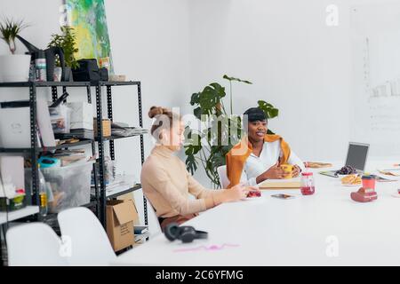 Freundliche Geschäftspartner trinken Tee in der Freizeit am Arbeitsplatz Stockfoto