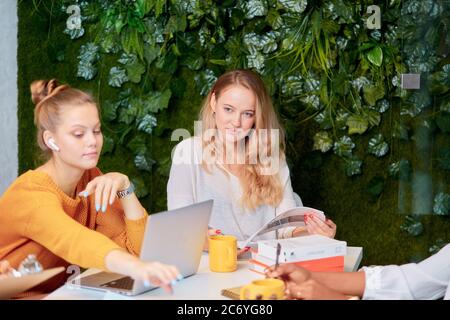 Erfolgreiches Coworking von kaukasischen Frauen, Zweisamkeit in der Arbeit. Selbstbewusste begeisterte Frauen versammelten sich, um zu diskutieren, im Executive Modern Office zu sprechen Stockfoto