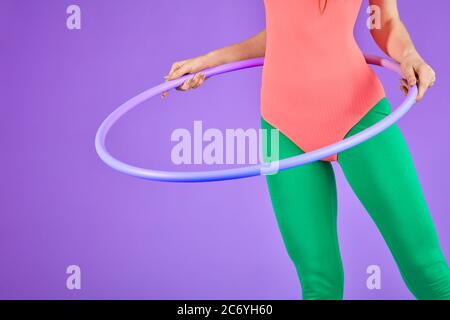 Halb Ansicht der unkenntlich Fitness Frau stehend und hält Hula Hoop, Aerobic-Übungen, hat schöne Körper Kurven, trägt rosa Trikot und Stockfoto