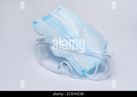 Maske und Schutzbrille für persönlichen Schutz auf hellgrauem Hintergrund Stockfoto