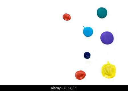 Mehrfarbige Acryl-Farbtropfen auf weißem Hintergrund. Rot, gelb, blau, grün, lila Farben. Speicherplatz kopieren. Stockfoto