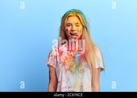 Lustige verspielte Mädchen mit schmutzigen Kleidern und Gesicht kippen den Augenzwinkern, Geheimnis, Frau mit Spaß, Madness.Isolated blauen Hintergrund, Studio erschossen Stockfoto