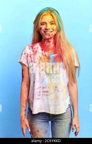 Lächelndes Mädchen, das an dem indischen Festival teilnimmt, isolierter blauer Hintergrund, Feier Konzept Stockfoto