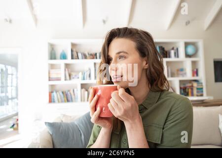 Frau hält Kaffeetasse zu Hause Stockfoto